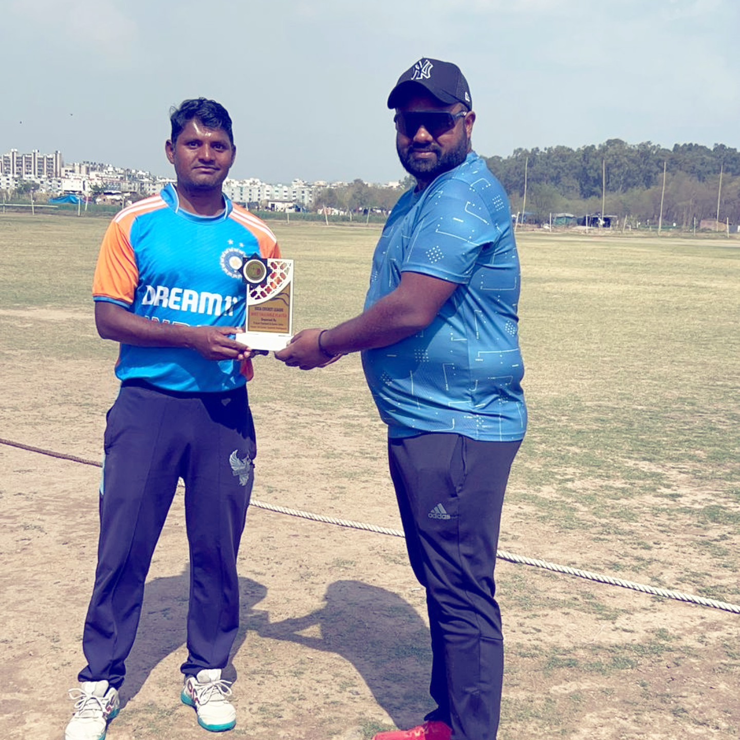 Raja Servai sharing a winning-trophy moment on the cricket ground